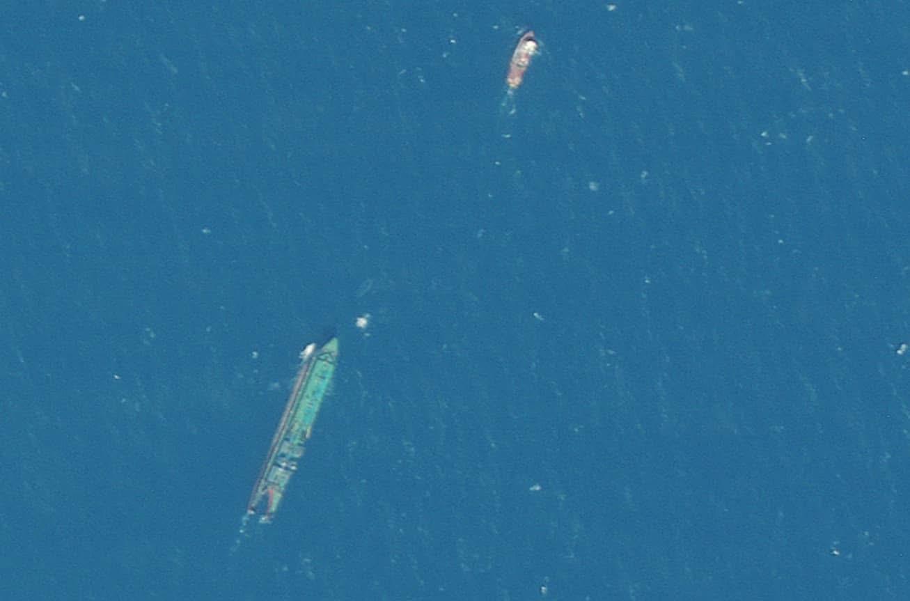 Close satellite view of a tug and barge at sea